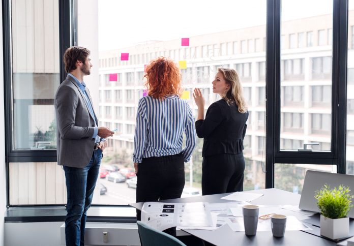 A group of young business people in an office, brainstorming