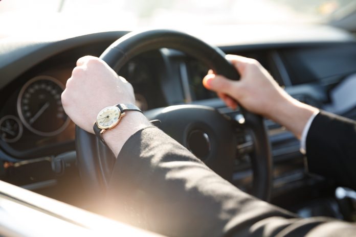 Cropped image of business man driving car