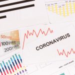 Inscription coronavirus, euro and downward graphs representing financial crisis caused by Covid-19